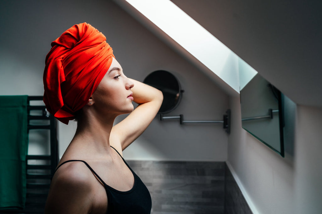 A woman wearing a green head wrap smiles. Side images show her in blue, red, and pink wraps.