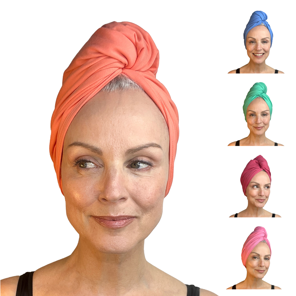 A person wearing "The End of Lines" coral head wrap from Good Wash Day smiles warmly. To the right, smaller images feature wraps in blue, green, pink, and purple. These vibrant wraps are made from organic jersey cotton by a small independent business.